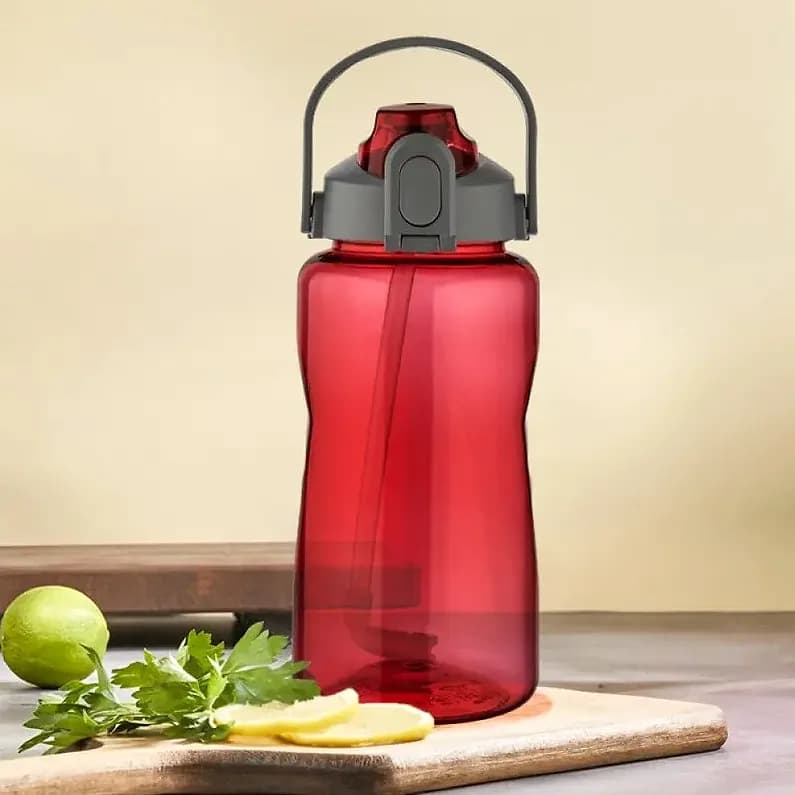 Kırmızı pipetli promosyon matara, ahşap tahta üzerinde limon ve maydanozla
