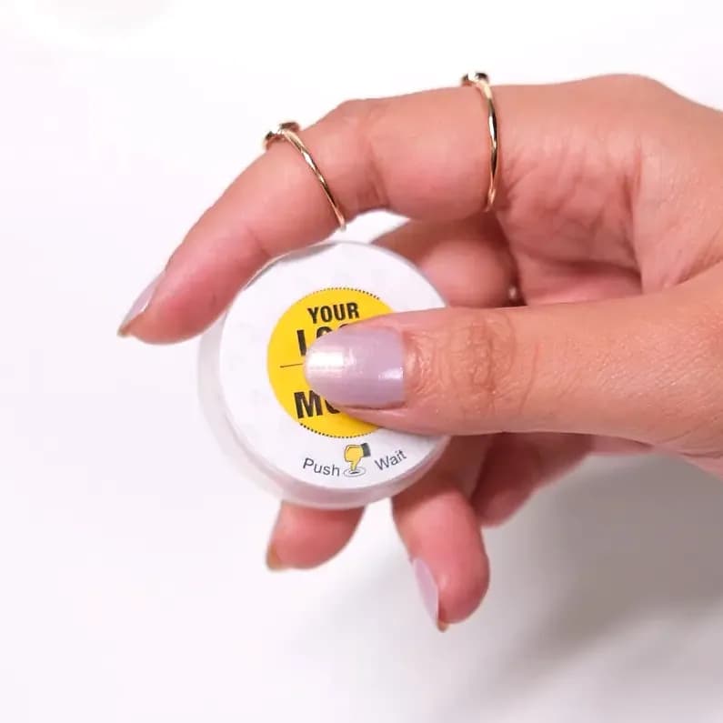 promosyon beyaz yuvarlak plastik kutu, elde tutuluyor, sarı etiketli, siyah yazı ve simge, beyaz zemin