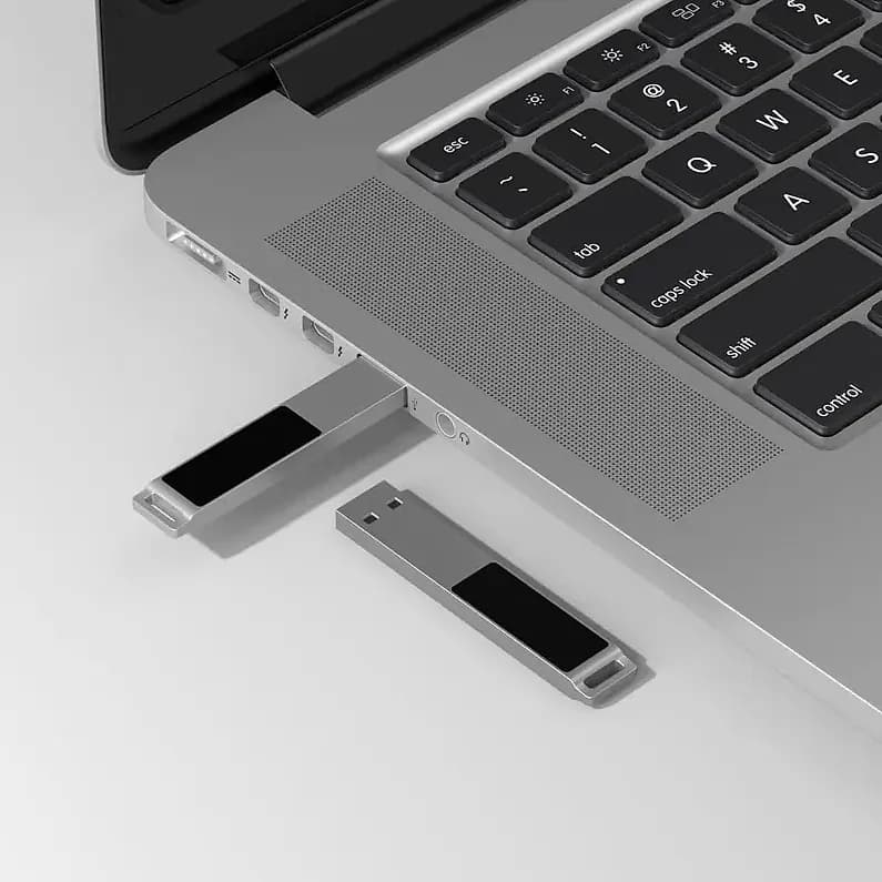 promosyon iki adet metal USB bellek, biri dizüstü portunda takılı, siyah panelli