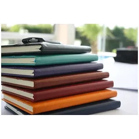 promosyon yedi renkli deri kapaklı defter yığını, dış mekanda bulanık fon önünde
