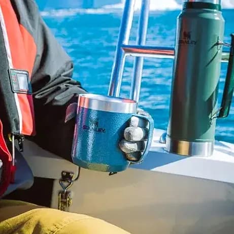 Promosyon benekli mavi kamp bardağı tekne güvertesinde, yanda yeşil termos