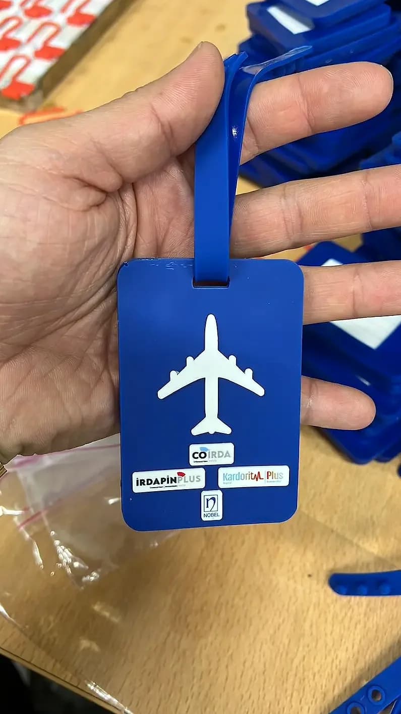 Promosyon mavi bavul etiketi, beyaz uçak silueti baskılı ve üretim ortamında elde