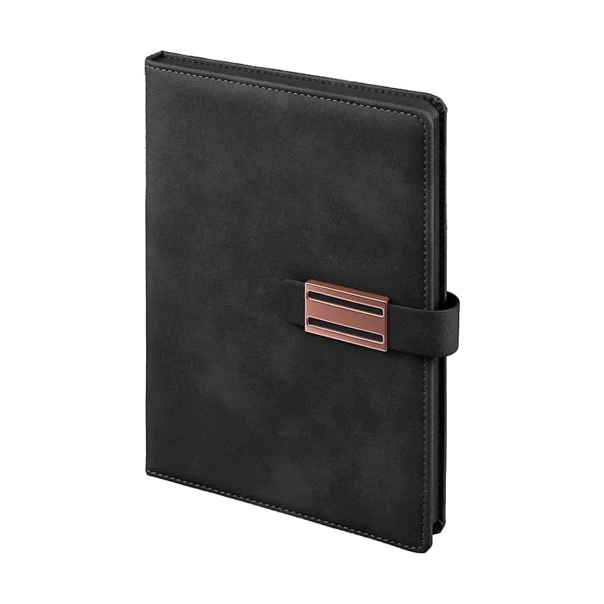 Siyah kapaklı defter; mat süet yüzey, yatay bant üzerinde bakır tonlu dikdörtgen metal toka.