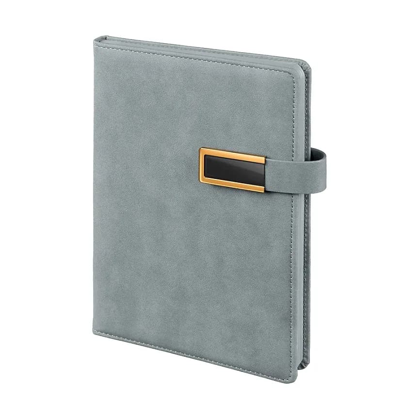 Mavi gri kapaklı defter; yumuşak mat doku, sağ kenarda altın çerçeveli siyah dikdörtgen metal plaka.