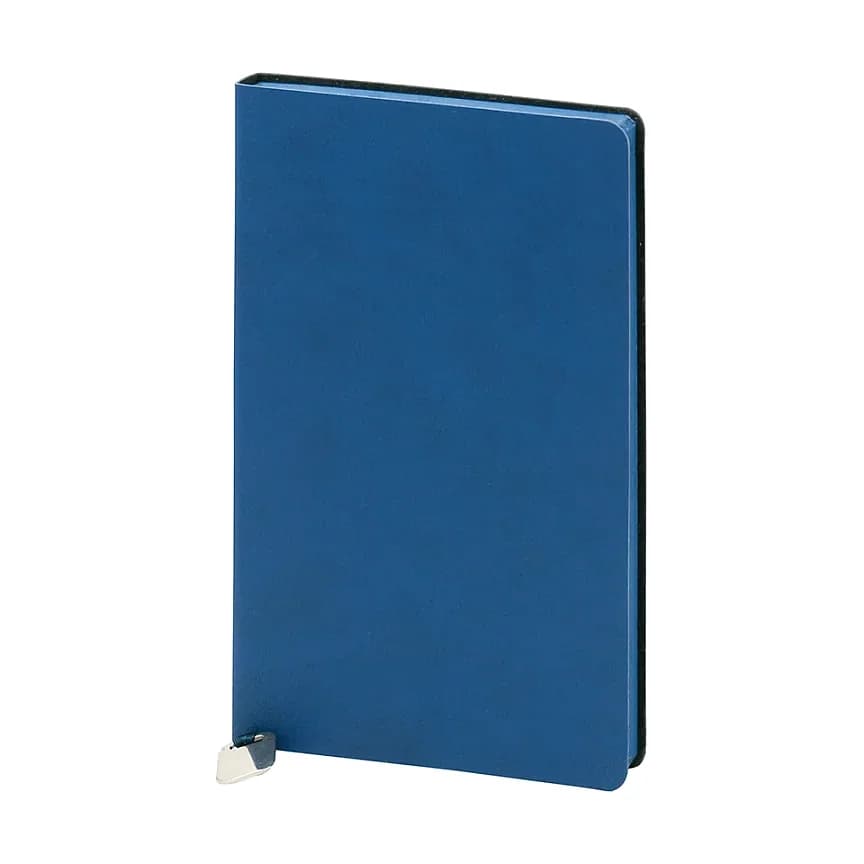 Düz mavi kapaklı defter; mat pürüzsüz yüzey, sol alt köşede gümüş oval metal parça ve koyu kenar.