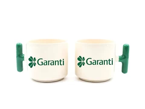 İki adet koyu yeşil kulplu krem promosyon latte fincanı, banka logosu baskılı
