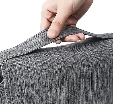 Gri çizgili çantanın üst sapı bir el tarafından kaldırılıyor.